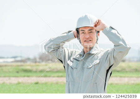 Middle-aged workers, craftsmen and site supervisors in work clothes standing in a rural rice field 124425039