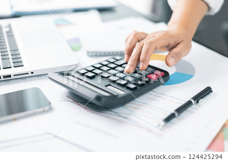 Businesswoman hand doing finances and calculate on desk about cost at home office. Business financing accounting banking concept. Woman working on desk with using calculator, finance accounting. 124425294