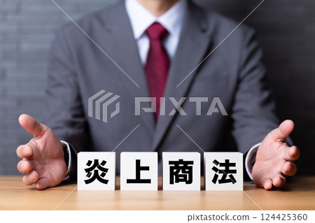 A middle-aged male businessman wearing a suit and a block of flame marketing 124425360