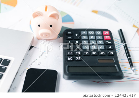 Piggy bank with business stuff, business and finance concept. calculators on financial statements, business chart showing financial success at the stock market 124425417