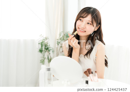 Young Asian woman applying make-up (lipstick, rouge, gloss, lips) 124425437