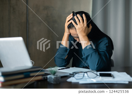 Tired business woman sleepy and bored from sitting at a desk for a long time and has office syndrome. Stressed business woman. Bored woman in office working with laptop and staring at computer screen 124425536