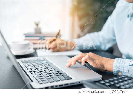 Businesswoman is deeply reviewing a financial report for a return on investment or investment risk analysis. Business woman working on documents looking concentrated with briefcase on table. Businesswoman is deeply reviewing a financial report for a return on investment or investment risk analysis. Business woman working on documents looking concentrated with briefcase on table. 124425603