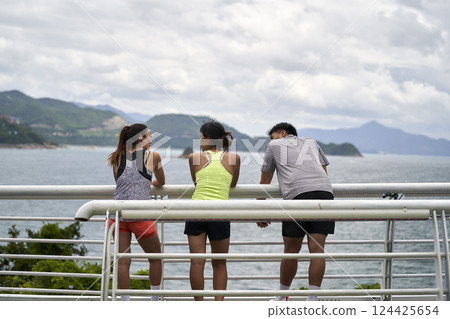 young asian people relaxing by the sea young asian people relaxing by the sea 124425654