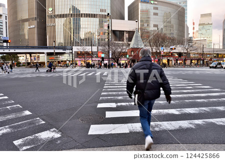 A man crossing the Sukiyabashi scramble crossing 124425866