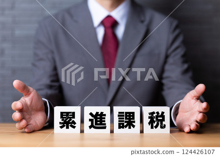 累進稅塊和一位穿著西裝的中年男性商人 124426107