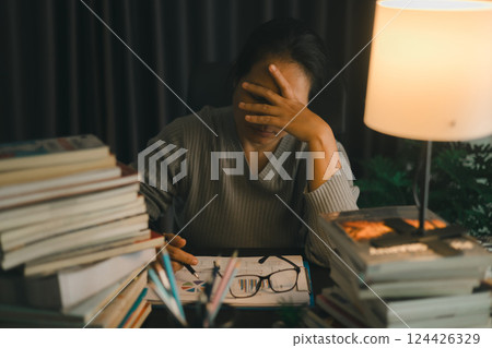 Depression at work. Asian Businesswoman sitting and working hard at with front of computer and lots of documents on table in workplace at late with serious action, Work hard and too late concept Depression at work. Asian Businesswoman sitting and working hard at with front of computer and lots of documents on table in workplace at late with serious action, Work hard and too late concept 124426329