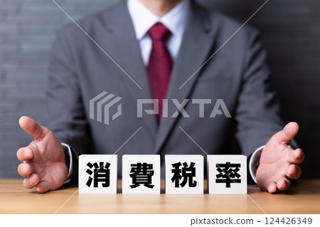A block of consumption tax rate and a middle-aged male businessman wearing a suit A block of consumption tax rate and a middle-aged male businessman wearing a suit 124426349