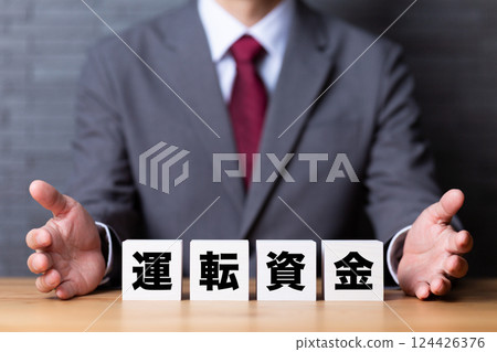 營運資本塊和穿西裝的中年男性商人 營運資本塊和穿西裝的中年男性商人 124426376