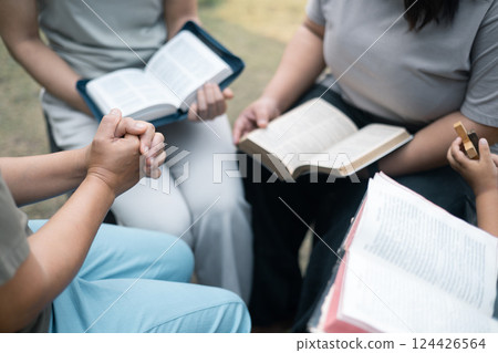 Christian woman held hands with the group, expressing their faith through prayer and devotion to God, uniting in their shared religion. Friends, Group christian pray concept. 124426564