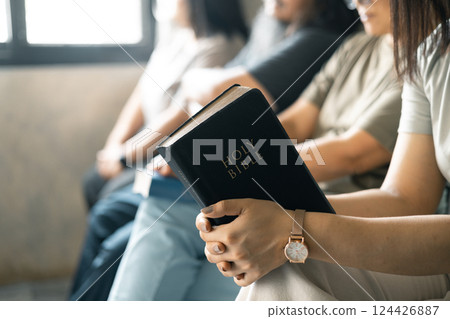 Group of Christian women sat together in chairs, holding their Bibles, feeling the togetherness of prayer and their religious connection to God. Group christian pray concept. 124426887