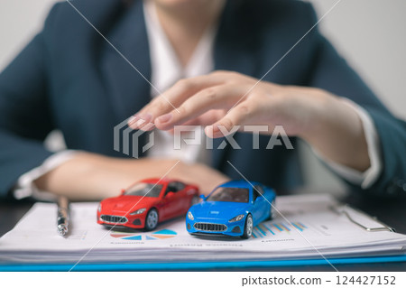 Car insurance concept. Agent negotiated a comprehensive insurance agreement for the auto business, covering all aspects of vehicle transport and automobile protection. Car insurance concept. Agent negotiated a comprehensive insurance agreement for the auto business, covering all aspects of vehicle transport and automobile protection. 124427152