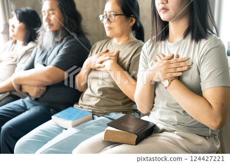 Group of Christian women sat together in chairs, holding their Bibles, feeling the togetherness of prayer and their religious connection to God. Group christian pray concept. Group of Christian women sat together in chairs, holding their Bibles, feeling the togetherness of prayer and their religious connection to God. Group christian pray concept. 124427221