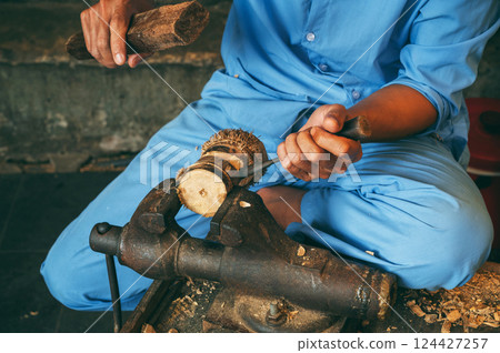 Male hands of a artisan craftsman carpenter wooden carving with a chisel in a workshop in Hoi An in Vietnam 124427257