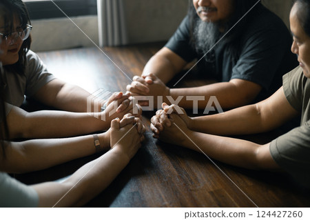 Woman gathered with her Christian friends in church, Bible close as they joined in prayer, feeling warmth of their religious family bond within group. Woman gathered with her Christian friends in church, Bible close as they joined in prayer, feeling warmth of their religious family bond within group. 124427260