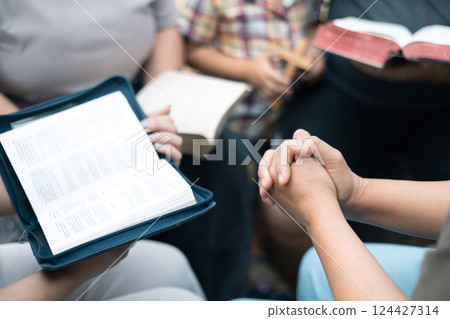 Christian woman held hands with the group, expressing their faith through prayer and devotion to God, uniting in their shared religion. Friends, Group christian pray concept. 124427314