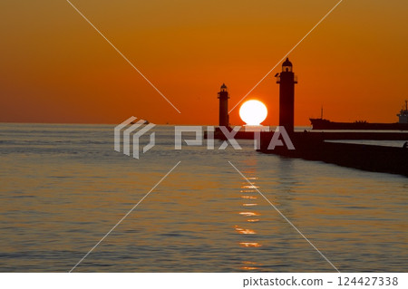 A daruma sunset sinking in the middle of the red and white lighthouse at Himeji Port A daruma sunset sinking in the middle of the red and white lighthouse at Himeji Port 124427338