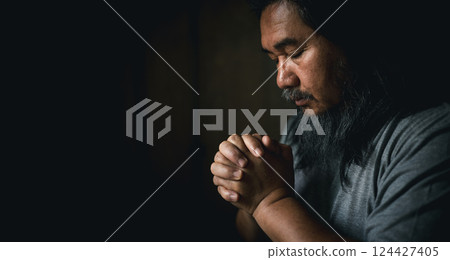 Person man, turned to God in prayer, demonstrating their religious faith and devotion through worship. Man hand in prayer, expressing his religious faith in God through worship of Jesus Christ. 124427405