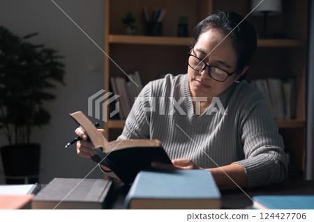 Woman with Bible in her hand, her faith unwavering as she prayed and worshiped God, finding strength and guidance in her Christian religion through the holy book. pray, woman, bible, faith, religion. 124427706