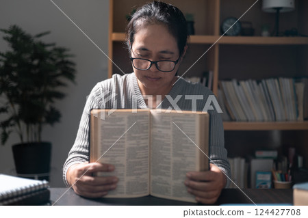 Woman, a person of deep faith, clutched the holy Bible as she knelt in prayer, worshiping with unwavering devotion and embracing the tenets of her Christian religion. bible, prayer, religion, woman. Woman, a person of deep faith, clutched the holy Bible as she knelt in prayer, worshiping with unwavering devotion and embracing the tenets of her Christian religion. bible, prayer, religion, woman. 124427708