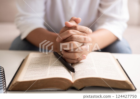Christian woman with faith and hope, raises her hand in worship to pray to God and Jesus Christ, embodying her religion. woman, hand, faith, pray, worship, jesus christ, christian, god, hope. 124427750