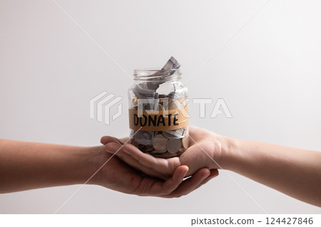Manage her income wisely she used jar to save coins and cash, balancing her financial needs between finance and desire to donate money. money, coin, finance, jar, financial, save, cash, donate. 124427846