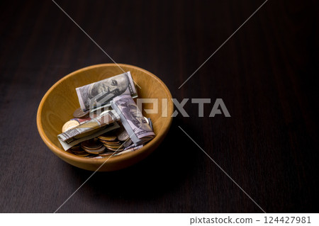 She felt deep sense of fulfillment when donating money to church, placing her tithe of coins and cash into offering bowl, knowing her giving would help fund important causes. donating, money, tithe. 124427981