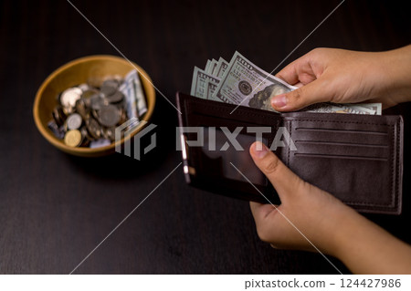 She felt deep sense of fulfillment when donating money to church, placing her tithe of coins and cash into offering bowl, knowing her giving would help fund important causes. donating, money, tithe. 124427986