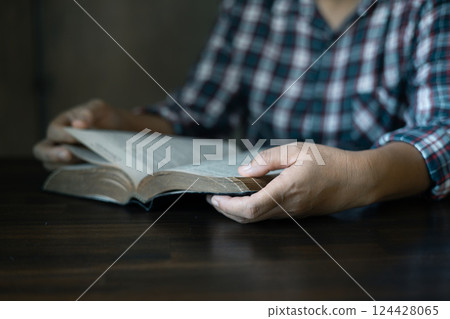Christian congregation gathered at church, each hand holding Bible, Unwavering faith, prayer and hope, seeking guidance of God through holy prayers. believers to worship, faith in Jesus Christ. 124428065