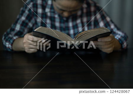 Christian congregation gathered at church, each hand holding Bible, Unwavering faith, prayer and hope, seeking guidance of God through holy prayers. believers to worship, faith in Jesus Christ. 124428067