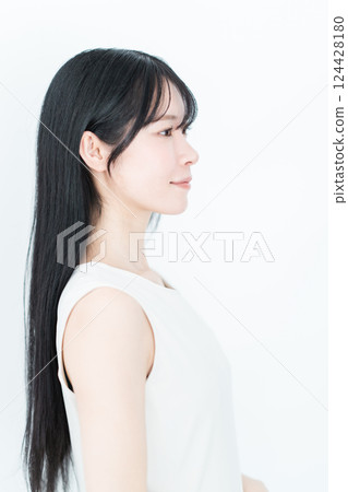 側身站立的長髮年輕女子的美女形象 側身站立的長髮年輕女子的美女形象 124428180