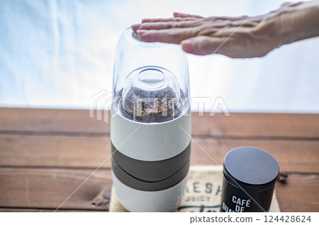 用電動研磨機研磨烘焙後的咖啡豆 用電動研磨機研磨烘焙後的咖啡豆 124428624