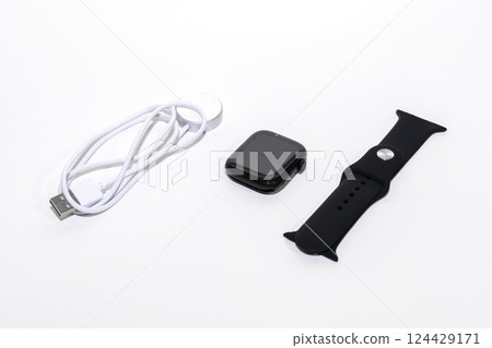 Black smart watch bracelet and charger on white background. 124429171