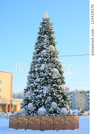 A beautifully snowcovered Christmas tree standing majestically in a winter wonderland A beautifully snowcovered Christmas tree standing majestically in a winter wonderland 124429376