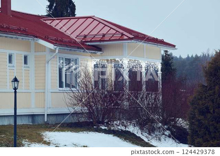 Beautiful and Charming Winter Cottage with a Bright Red Roof Set in a Picturesque Snowy Landscape 124429378