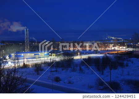 A serene winter night scene with vibrant industrial activity in a tranquil snowy landscape A serene winter night scene with vibrant industrial activity in a tranquil snowy landscape 124429451