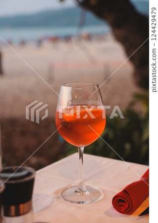 Experience the refreshing taste of a Sunset Cocktail served on a lovely beachside table Experience the refreshing taste of a Sunset Cocktail served on a lovely beachside table 124429479