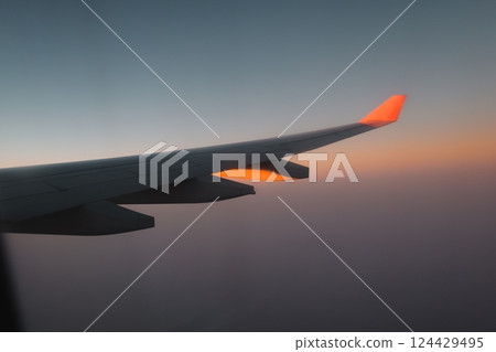 A Beautiful and Scenic View from an Airplane Wing During a Majestic Sunset in the Sky 124429495