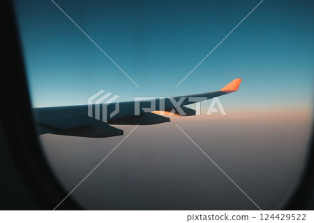 An Airplane Wing Silhouette Set Against a Beautifully Colorful Sky at Dusk During Sunset An Airplane Wing Silhouette Set Against a Beautifully Colorful Sky at Dusk During Sunset 124429522