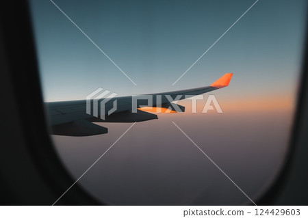 Im enjoying a beautiful sunset view from my airplane window on this memorable journey 124429603