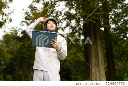 A woman in work clothes performing maintenance 124429652