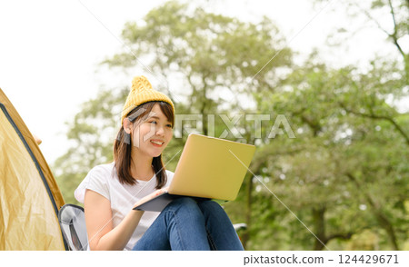A woman operating a PC outdoors A woman operating a PC outdoors 124429671