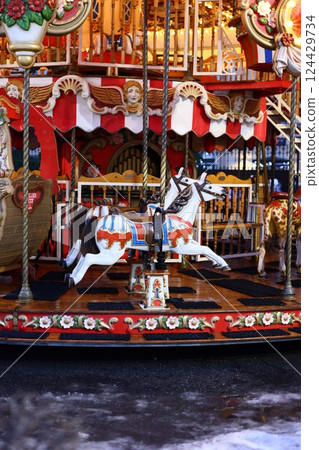 This is a vibrant and colorful Vintage Carousel Horse situated near a picturesque body of water 124429734