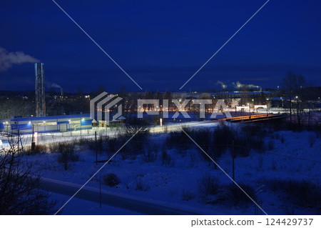 A captivating winter night scene featuring an industrial background, complete with snow A captivating winter night scene featuring an industrial background, complete with snow 124429737