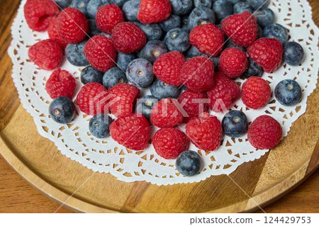 A Beautiful Arrangement of Fresh Berries on a Delicate Lace Doily A Vibrant Display A Beautiful Arrangement of Fresh Berries on a Delicate Lace Doily A Vibrant Display 124429753