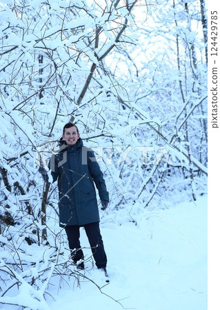 A person stands peacefully in a stunning snowy winter wonderland filled with tranquility A person stands peacefully in a stunning snowy winter wonderland filled with tranquility 124429785