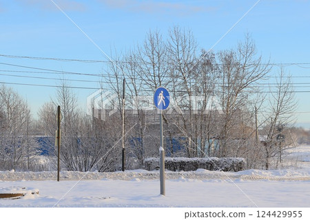 A beautiful winter scene showcasing a snowcovered pathway alongside a pedestrian sign 124429955