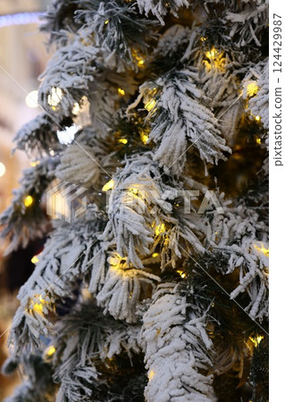 Beautiful and Festive Holiday Decor featuring Snowy Pine and Twinkling Lights for ambiance 124429987