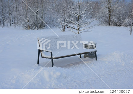 A SnowCovered Park Bench Olive Green Amidst a Picturesque Winter Wonderland Scene 124430037