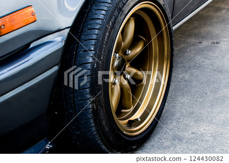 Close-up of gold alloy wheel with tire 124430082